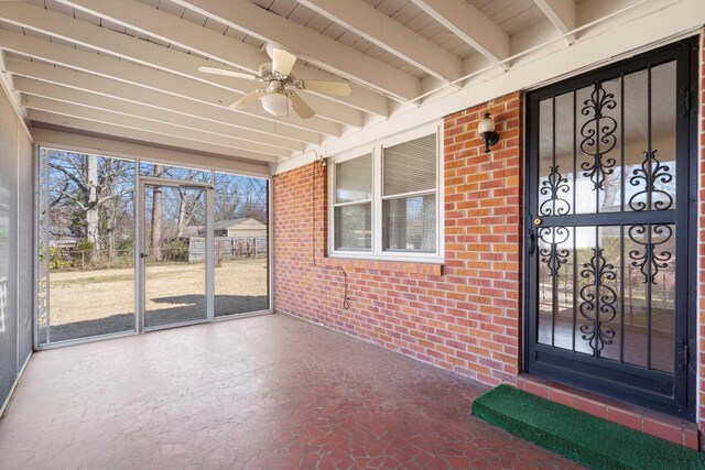 view of exterior entry featuring a ceiling fan and brick siding