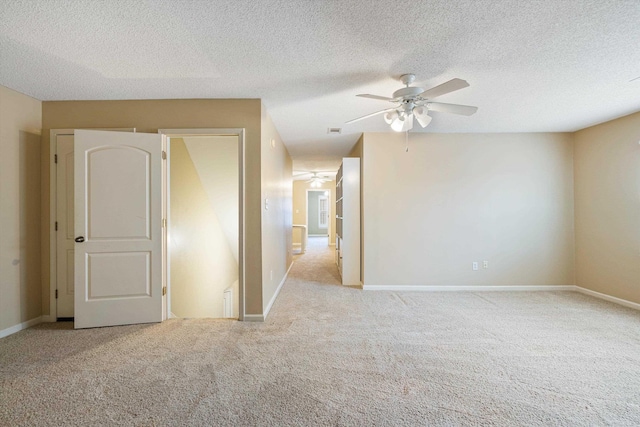 spare room with baseboards, a textured ceiling, and carpet flooring