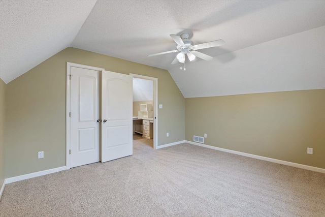 bonus room featuring light carpet, baseboards, visible vents, and a textured ceiling