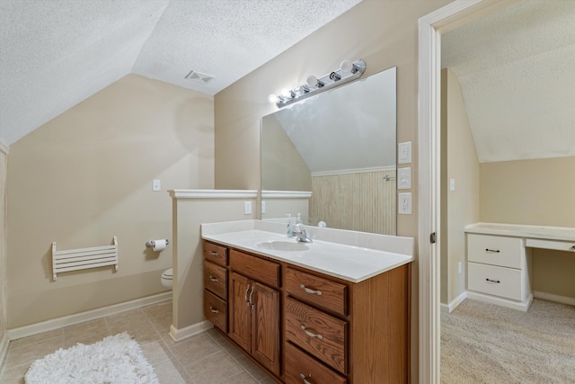 bathroom with visible vents, toilet, vanity, vaulted ceiling, and a textured ceiling