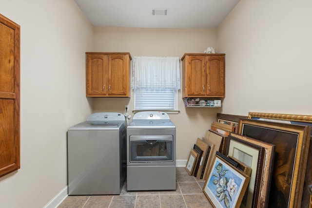 laundry area featuring light tile patterned floors, baseboards, visible vents, cabinet space, and washer and clothes dryer