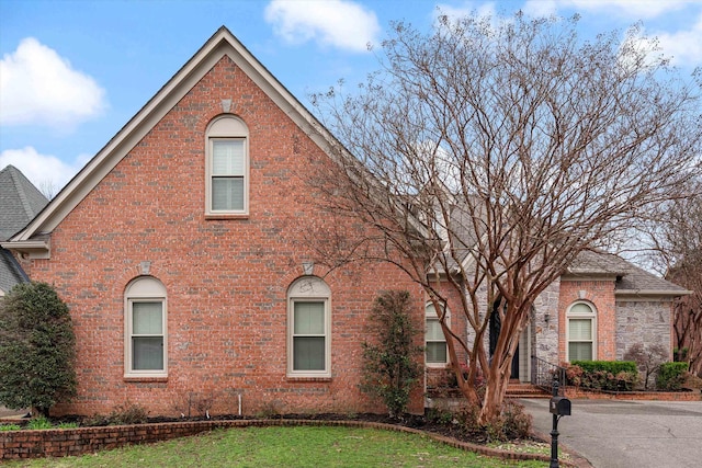 view of front facade with a front lawn and brick siding