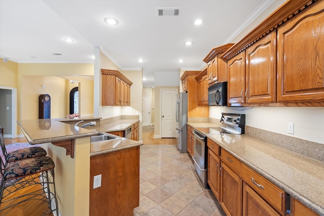 kitchen with visible vents, ornamental molding, a sink, appliances with stainless steel finishes, and a kitchen bar