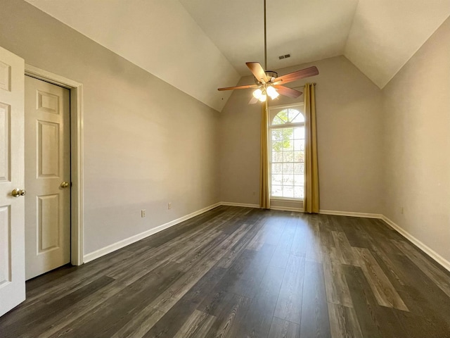 spare room featuring visible vents, lofted ceiling, a ceiling fan, dark wood finished floors, and baseboards