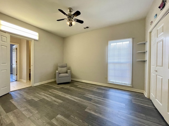 unfurnished room with dark wood finished floors, visible vents, baseboards, and ceiling fan