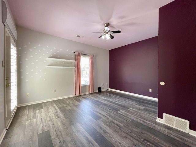 unfurnished room with visible vents, baseboards, and wood finished floors