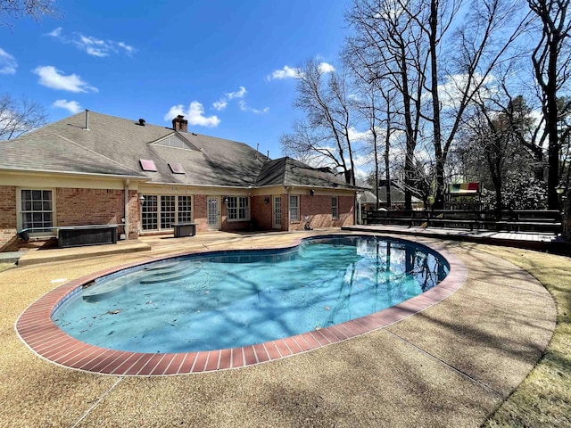 view of swimming pool featuring a patio area, a fenced in pool, and a hot tub