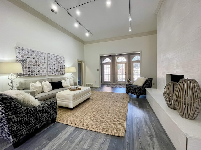 living area with visible vents, ornamental molding, and wood finished floors