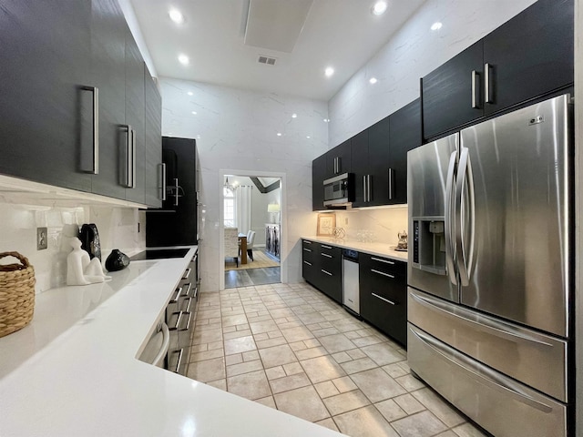 kitchen with stainless steel appliances, visible vents, dark cabinets, and light countertops