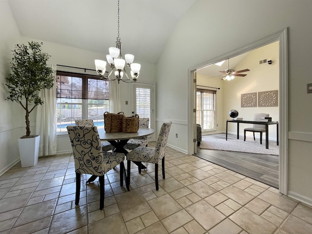 dining space with ceiling fan with notable chandelier and high vaulted ceiling