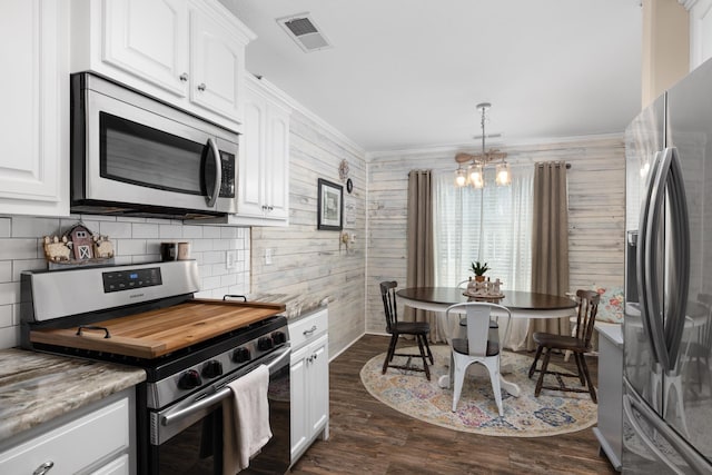 kitchen featuring visible vents, ornamental molding, dark wood-type flooring, appliances with stainless steel finishes, and white cabinetry