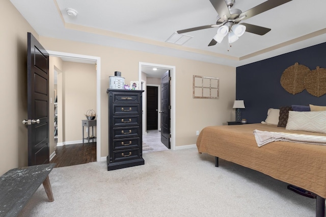 bedroom featuring baseboards, a raised ceiling, and carpet floors