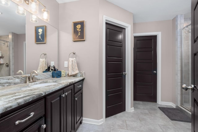 bathroom featuring tile patterned flooring, a stall shower, vanity, and baseboards