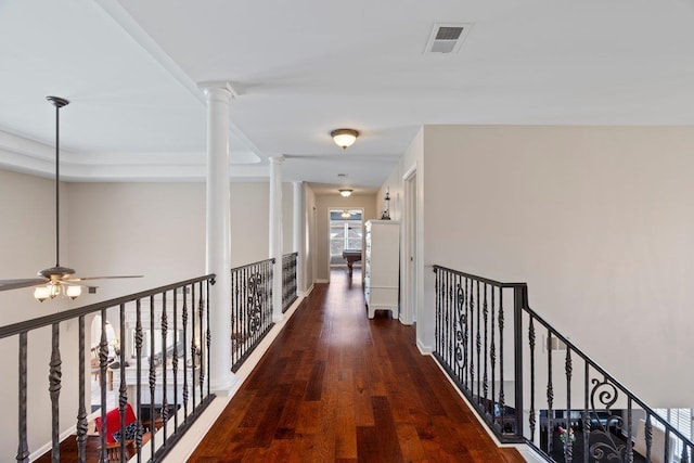 hallway with visible vents, ornate columns, and wood finished floors