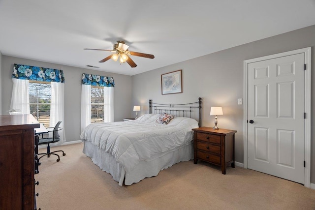 bedroom with baseboards, light carpet, visible vents, and a ceiling fan