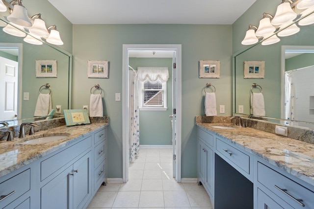 bathroom with a sink, two vanities, and tile patterned floors