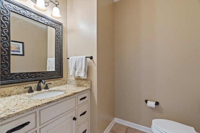 half bathroom with tile patterned floors, baseboards, toilet, and vanity