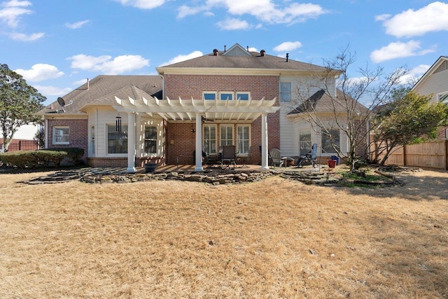 rear view of property featuring fence, a yard, a pergola, a patio area, and brick siding