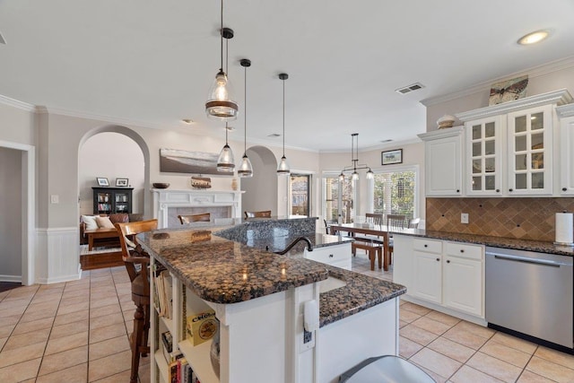 kitchen featuring visible vents, arched walkways, a sink, dishwasher, and crown molding