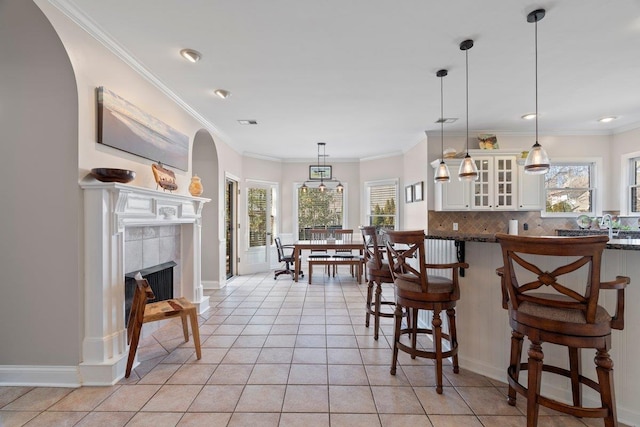 kitchen featuring arched walkways, backsplash, and ornamental molding