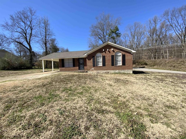 ranch-style home with an attached carport, driveway, brick siding, and a front yard