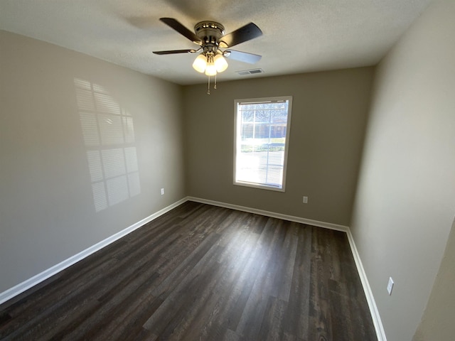 unfurnished room featuring dark wood-style floors, ceiling fan, a textured ceiling, and baseboards