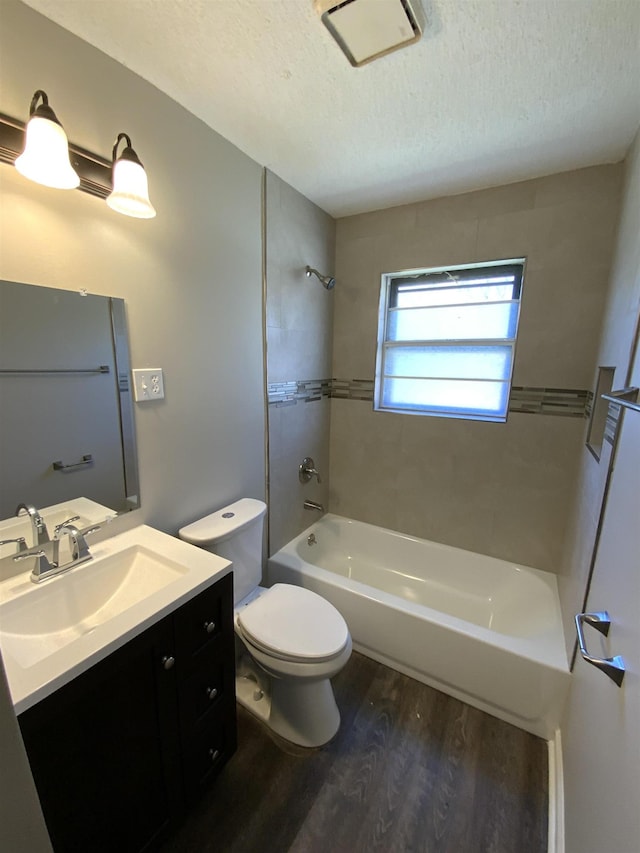 full bath featuring toilet, vanity, bathtub / shower combination, wood finished floors, and a textured ceiling