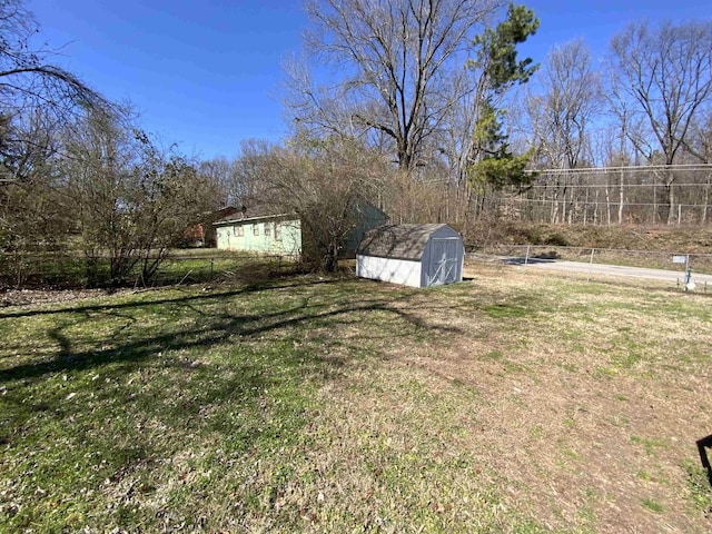 view of yard with a storage shed, an outdoor structure, and fence