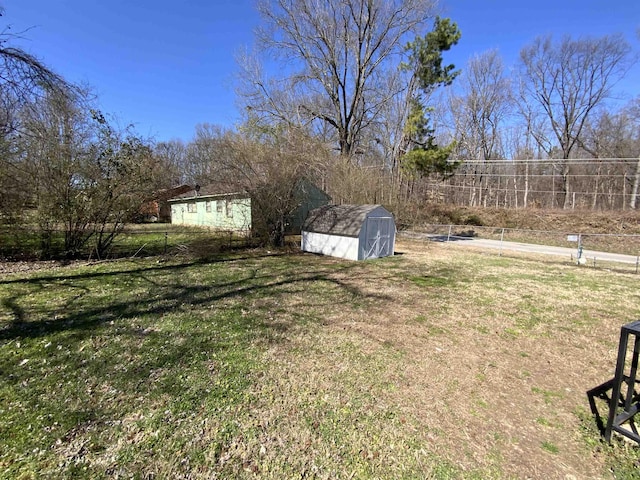 view of yard with an outbuilding, a storage unit, and fence