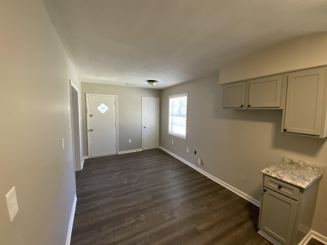 interior space with baseboards and dark wood-style flooring