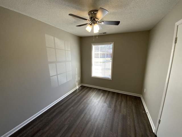 unfurnished room with visible vents, dark wood-type flooring, ceiling fan, baseboards, and a textured ceiling