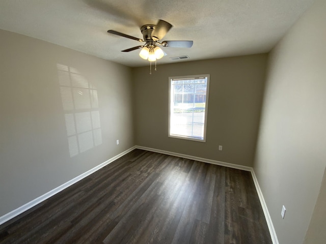 unfurnished room featuring ceiling fan, baseboards, dark wood-style flooring, and a textured ceiling