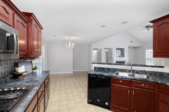 kitchen with ceiling fan with notable chandelier, a sink, stainless steel appliances, reddish brown cabinets, and a fireplace