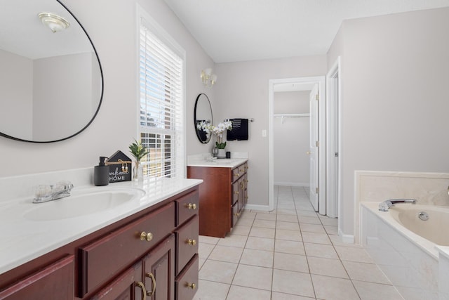 bathroom featuring tile patterned floors, a garden tub, two vanities, a sink, and baseboards