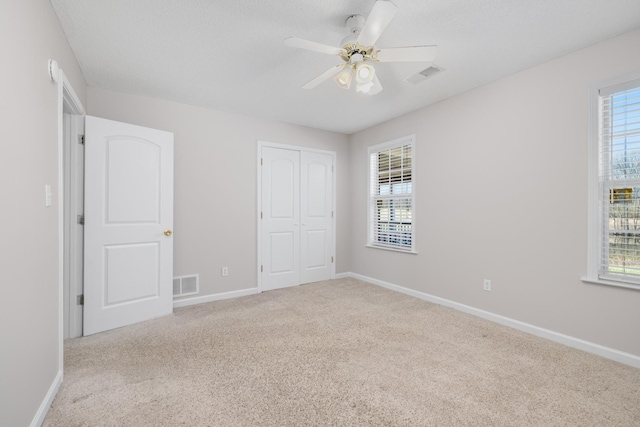 unfurnished bedroom featuring a closet, baseboards, visible vents, and carpet floors