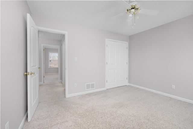 unfurnished bedroom featuring attic access, carpet flooring, baseboards, and visible vents