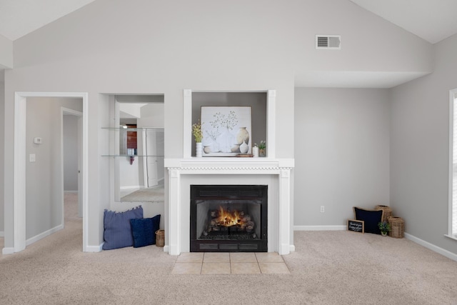 unfurnished living room with carpet, visible vents, baseboards, lofted ceiling, and a fireplace with flush hearth