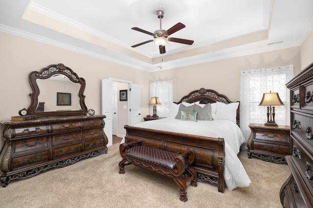 bedroom featuring visible vents, crown molding, a tray ceiling, and carpet