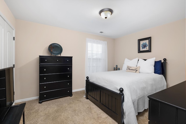 bedroom featuring light carpet and baseboards