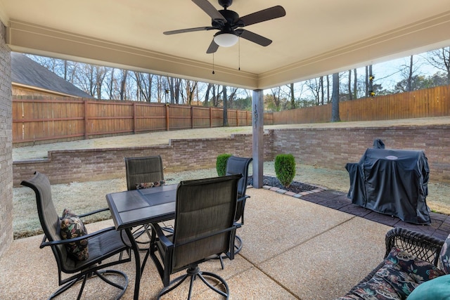 view of patio with grilling area, outdoor dining space, a ceiling fan, and a fenced backyard