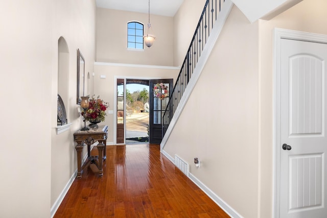 entrance foyer with stairs, visible vents, baseboards, and hardwood / wood-style floors