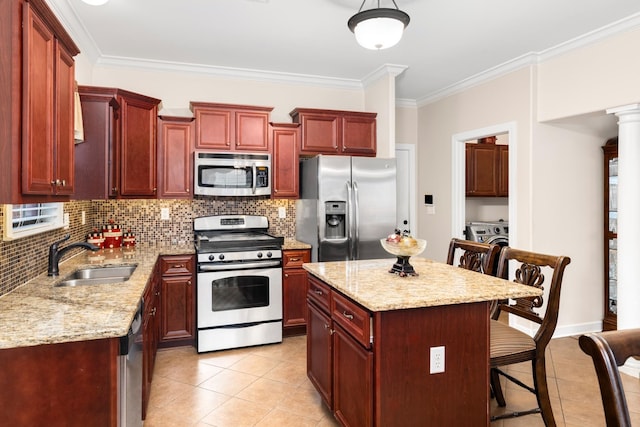 kitchen featuring a kitchen bar, dark brown cabinets, appliances with stainless steel finishes, and a sink