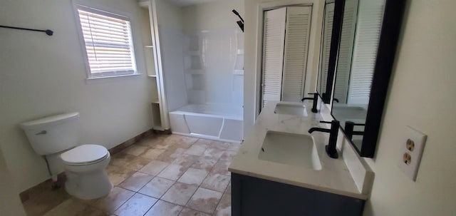 bathroom featuring double vanity, toilet, baseboards, and a sink