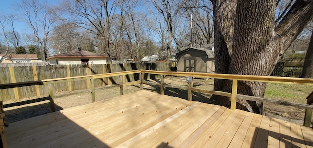 wooden deck featuring a fenced backyard, an outdoor structure, and a shed