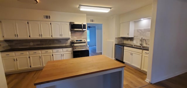 kitchen featuring white cabinets, visible vents, appliances with stainless steel finishes, and a sink