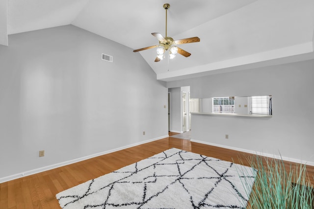 unfurnished room featuring visible vents, a ceiling fan, wood finished floors, baseboards, and vaulted ceiling