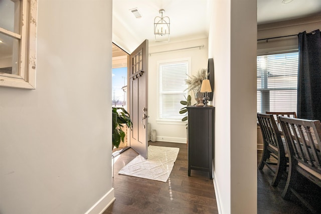 hallway featuring visible vents, baseboards, and hardwood / wood-style floors