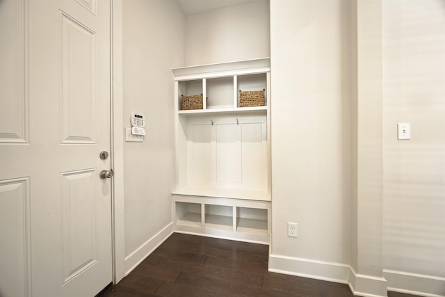 mudroom featuring dark wood-type flooring and baseboards