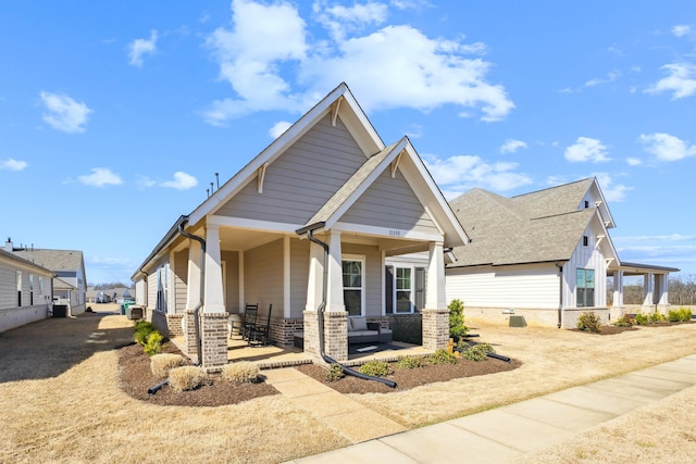 view of front of home with cooling unit, brick siding, and covered porch