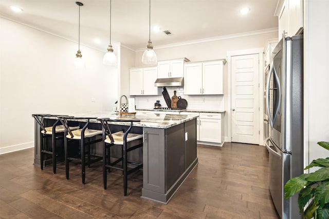 kitchen with visible vents, an island with sink, dark wood-style flooring, under cabinet range hood, and appliances with stainless steel finishes